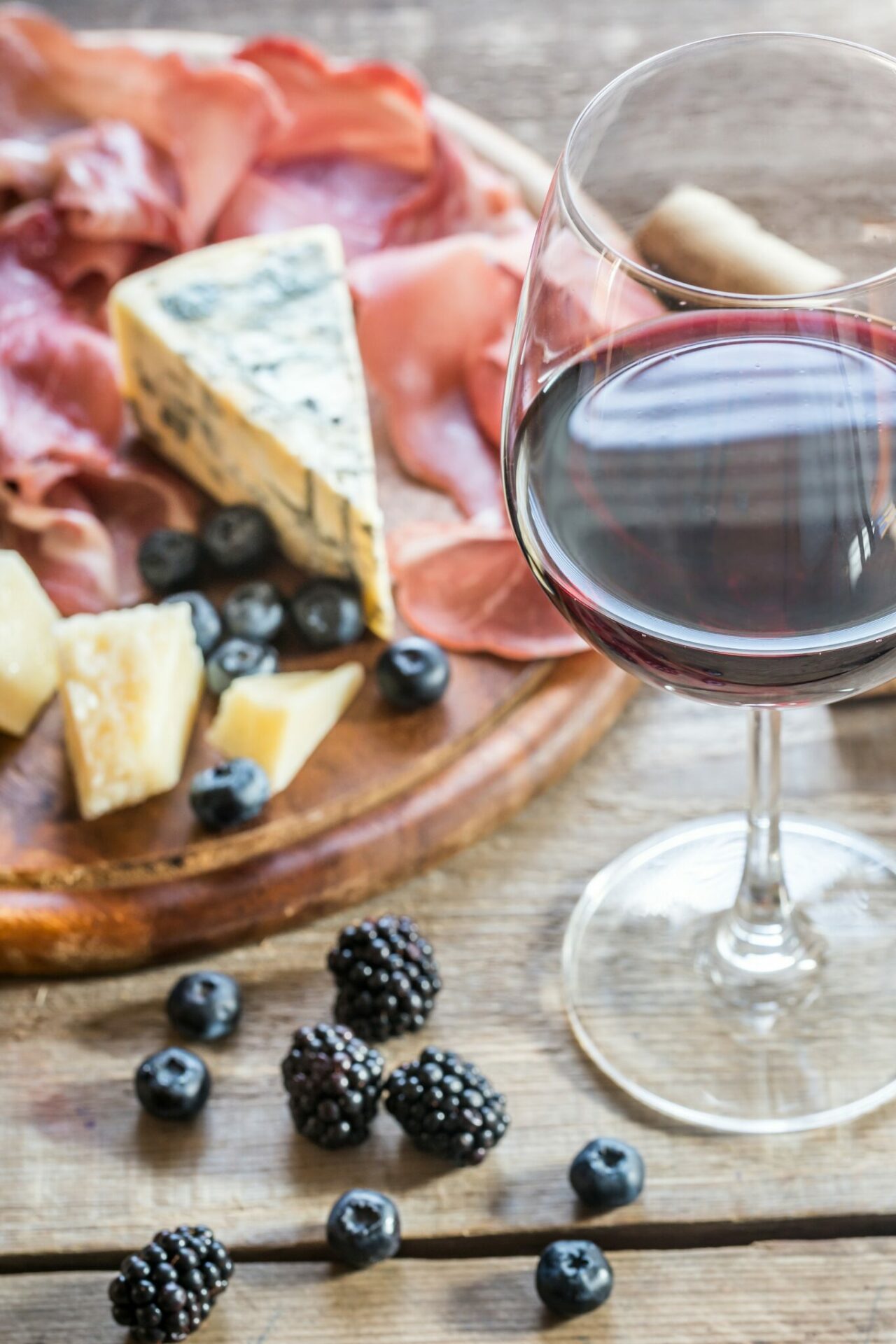 A glass of Malbec wine with food on a table