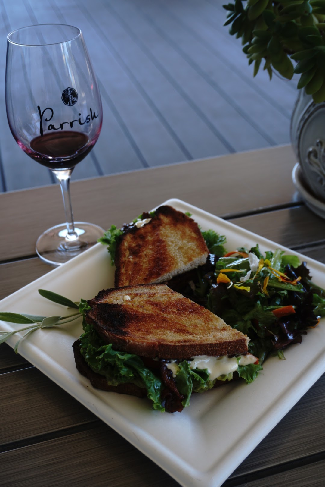 A plate of food with a glass of Parrish wine in Paso Robles Wineries