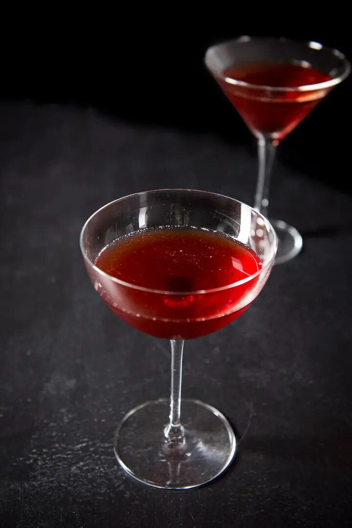 Cherry Manhattan Sweet Cocktails with a black background and two glasses.