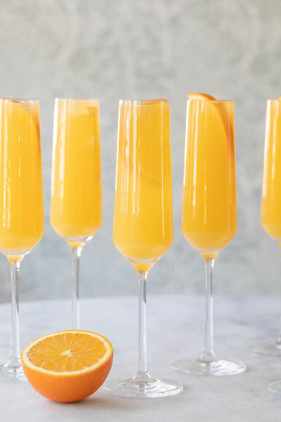 Classic Mimosa Sweet Cocktails With 5 glasses and orange by the side