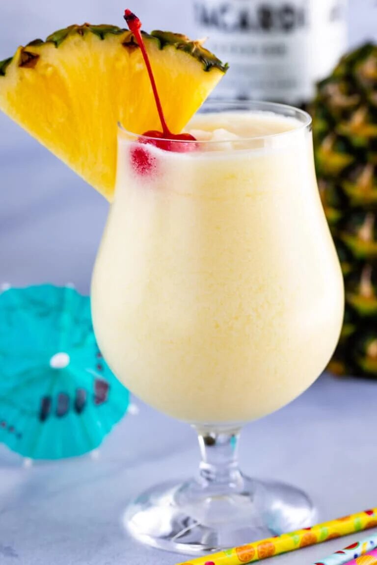 Pina Colada Sweet Cocktails sitting in a glass with a cherry on top