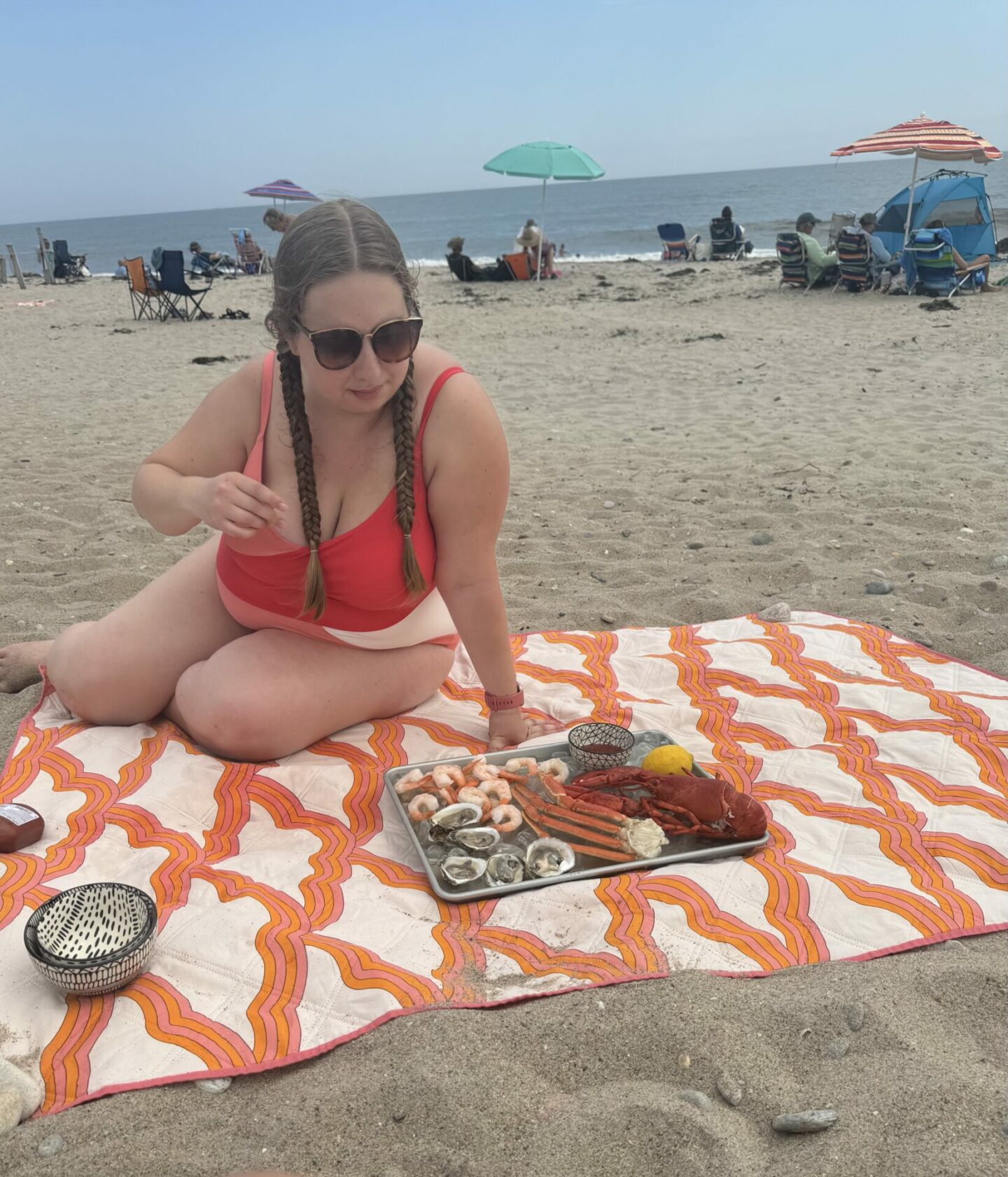 Girl sitting on beach with seafood platter