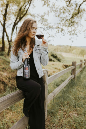 A lady resting by the ranch with a glass of Amarone Wine