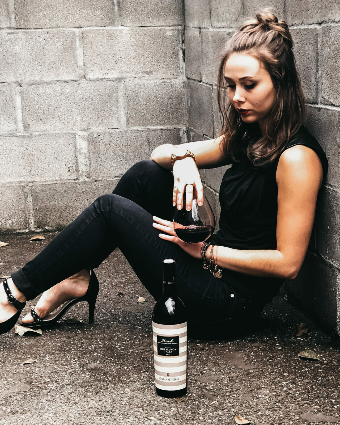 A lady sitting on the floor with Barolo wine