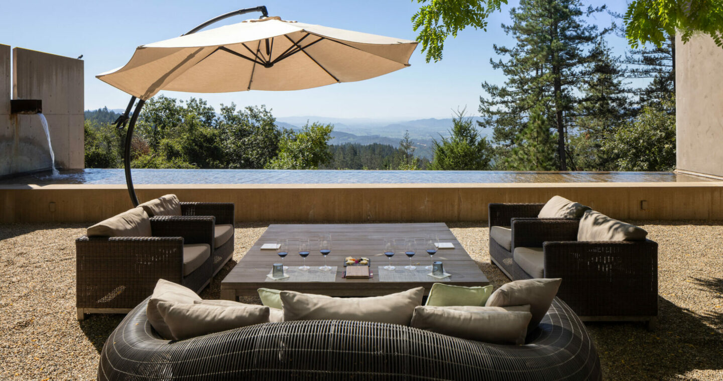 Umbrella and chairs on patio overlooking pond and mountains