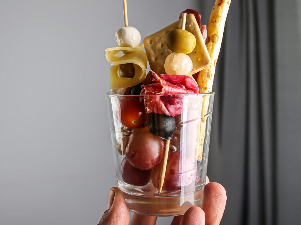 A hand holding a Charcuterie Cup