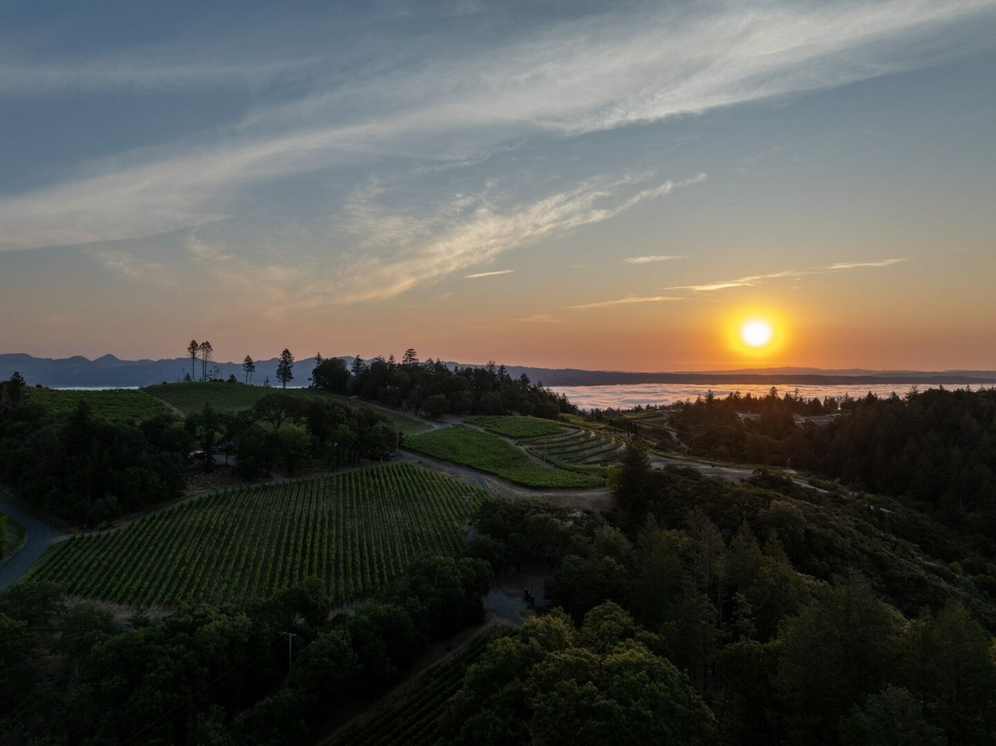 Sunset over mountains with water view in distance